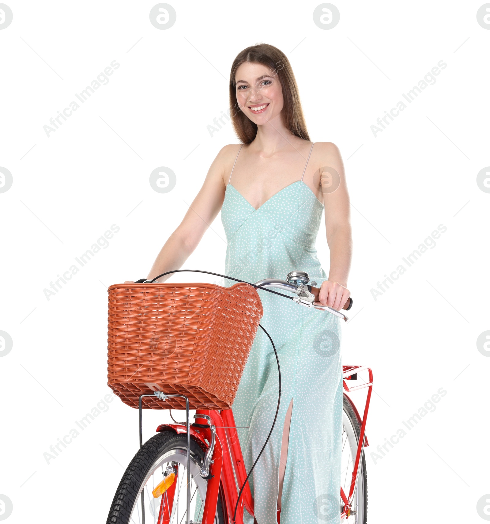Smiling woman in dress posing on bicycle with basket against white background Photo of Smiling woman in dress posing on bicycle with basket against white background