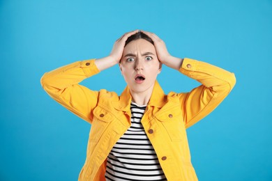 Photo of Portrait of shocked woman on light blue background