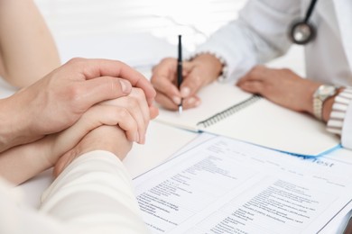 Photo of In vitro fertilization (IVF). Couple having consultation with doctor in reproductive clinic, closeup