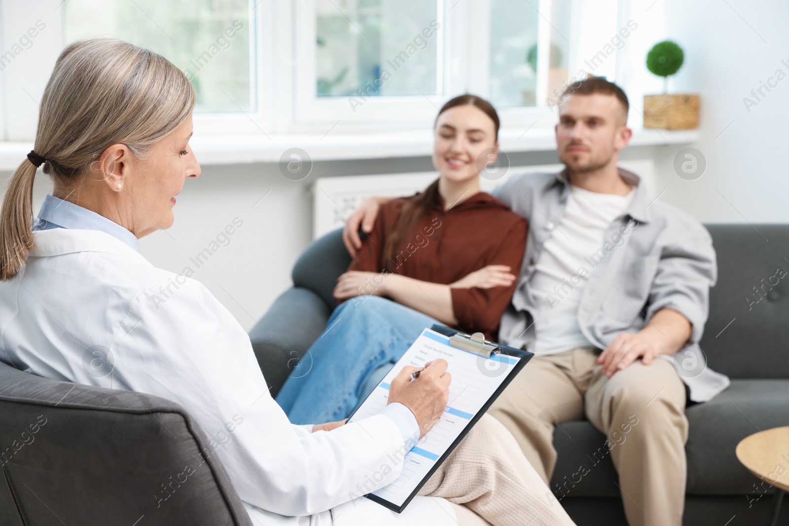 Photo of In vitro fertilization (IVF). Couple having consultation with doctor in reproductive clinic, selective focus