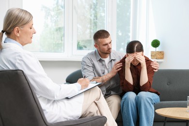 Photo of In vitro fertilization (IVF). Upset couple having consultation with doctor in reproductive clinic
