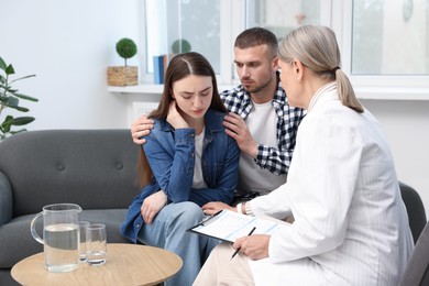Photo of In vitro fertilization (IVF). Upset couple having consultation with doctor in reproductive clinic