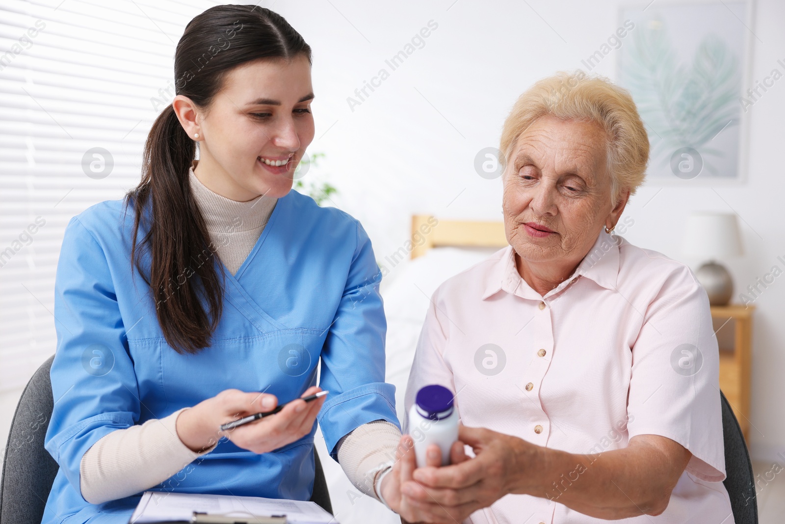 Nurse giving pills to senior woman indoors. Home health care service Photo of Nurse giving pills to senior woman indoors. Home health care service