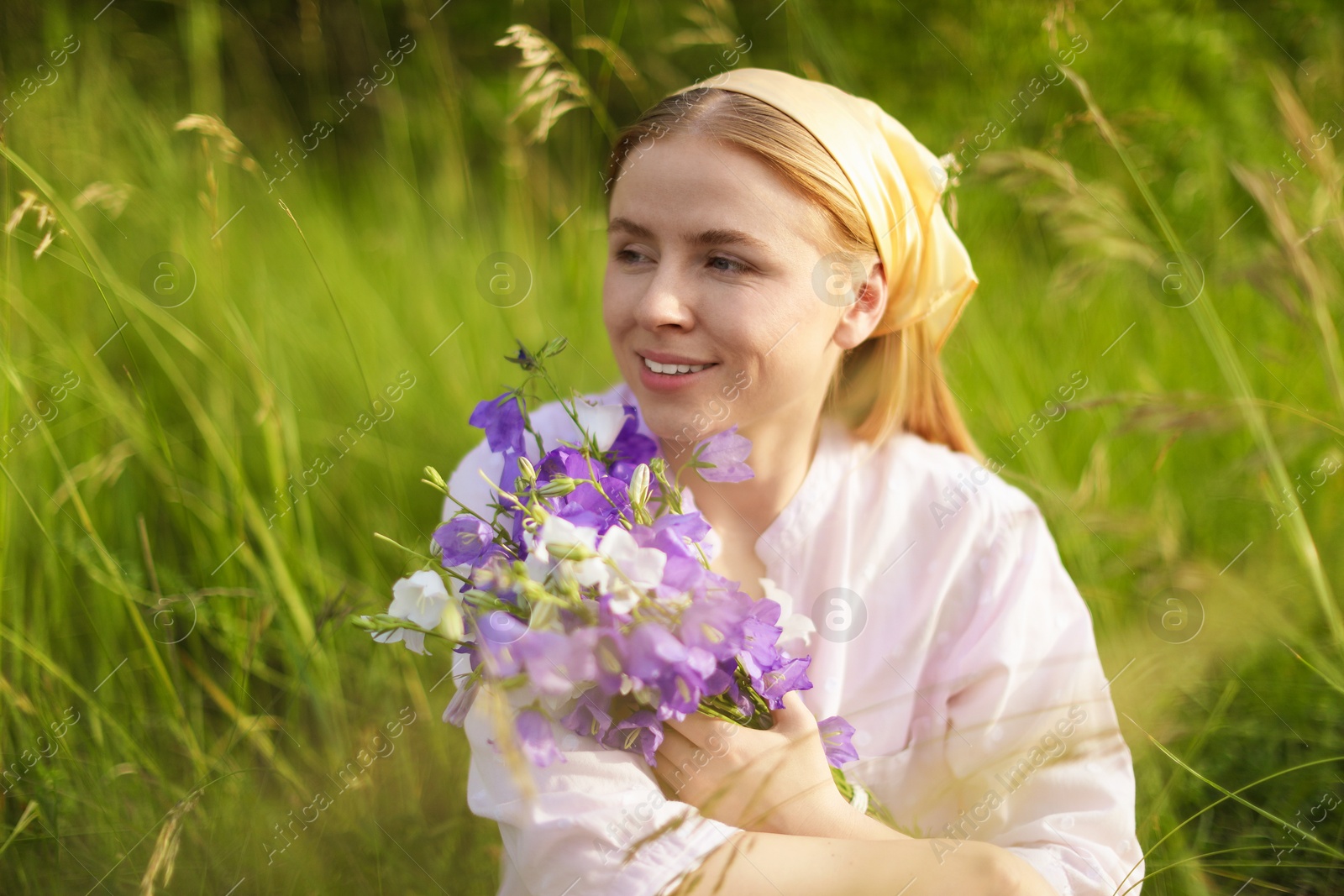 Beautiful woman with bouquet of wildflowers in meadow Photo of Beautiful woman with bouquet of wildflowers in meadow