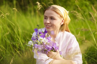 Photo of Beautiful woman with bouquet of wildflowers in meadow