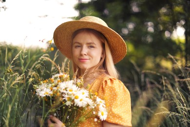 Photo of Beautiful woman with bouquet of wildflowers in meadow