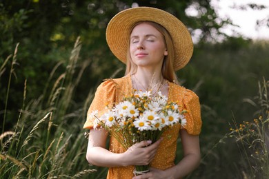 Photo of Beautiful woman with bouquet of wildflowers in meadow