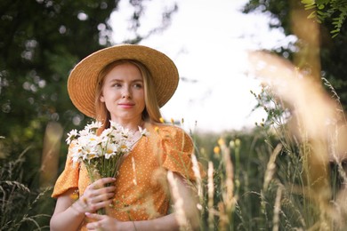 Photo of Beautiful woman with bouquet of wildflowers in meadow