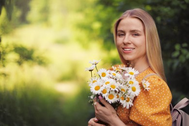 Photo of Beautiful woman with bouquet of wildflowers in forest