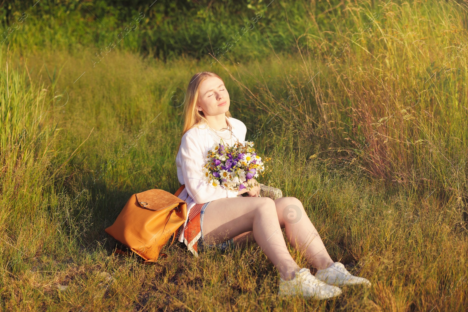 Woman with bouquet of beautiful wildflowers outdoors on sunny day Photo of Woman with bouquet of beautiful wildflowers outdoors on sunny day
