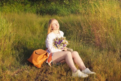 Photo of Woman with bouquet of beautiful wildflowers outdoors on sunny day