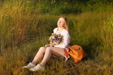 Photo of Woman with bouquet of beautiful wildflowers outdoors on sunny day
