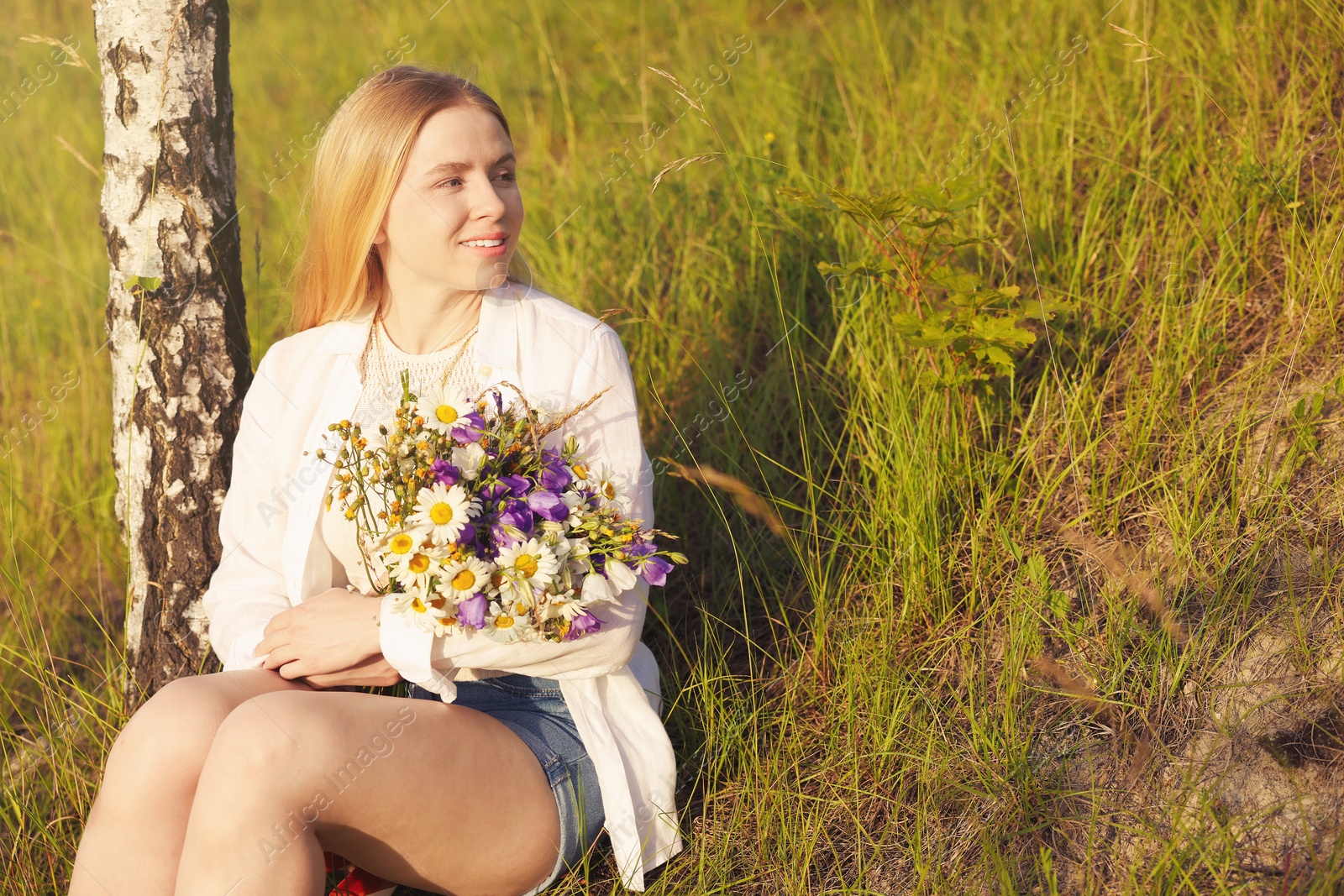 Woman with bouquet of beautiful wildflowers outdoors on sunny day. Space for text Photo of Woman with bouquet of beautiful wildflowers outdoors on sunny day. Space for text