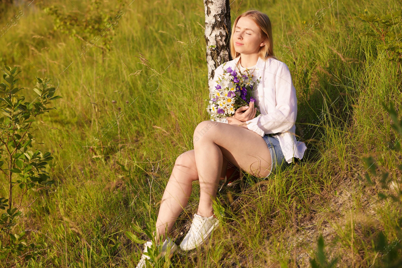 Photo of Woman with bouquet of beautiful wildflowers outdoors on sunny day