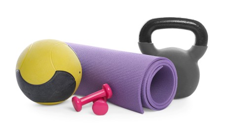 Photo of Medicine ball, dumbbells, kettlebell and fitness mat isolated on white