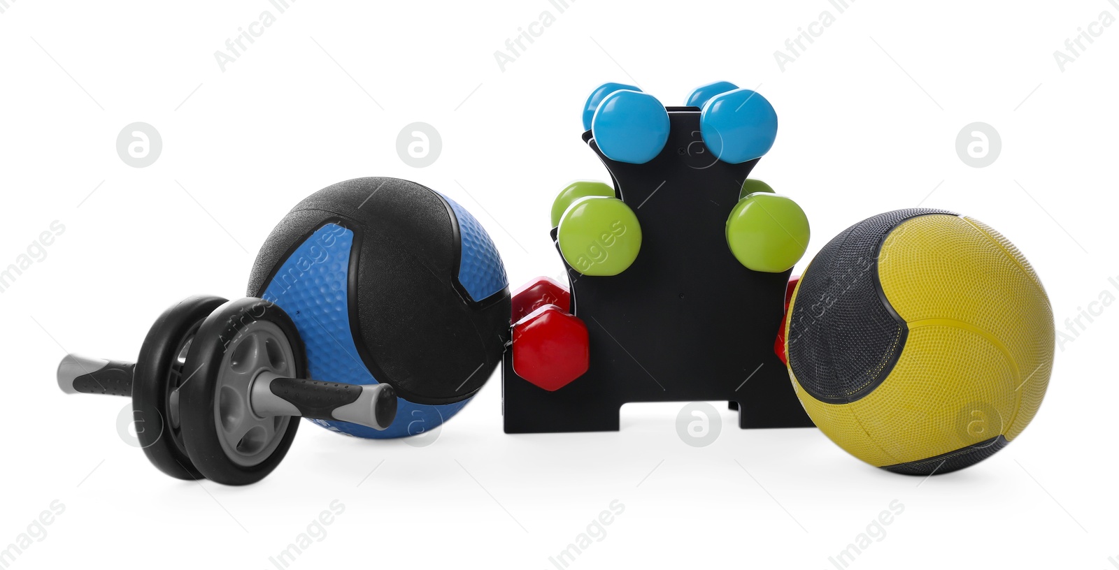 Medicine balls, dumbbells and ab wheel isolated on white Photo of Medicine balls, dumbbells and ab wheel isolated on white
