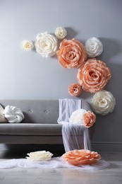 Photo of Photo zone with stylish floral decor and sofa in studio