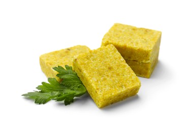 Photo of Tasty aromatic bouillon cubes and parsley isolated on white