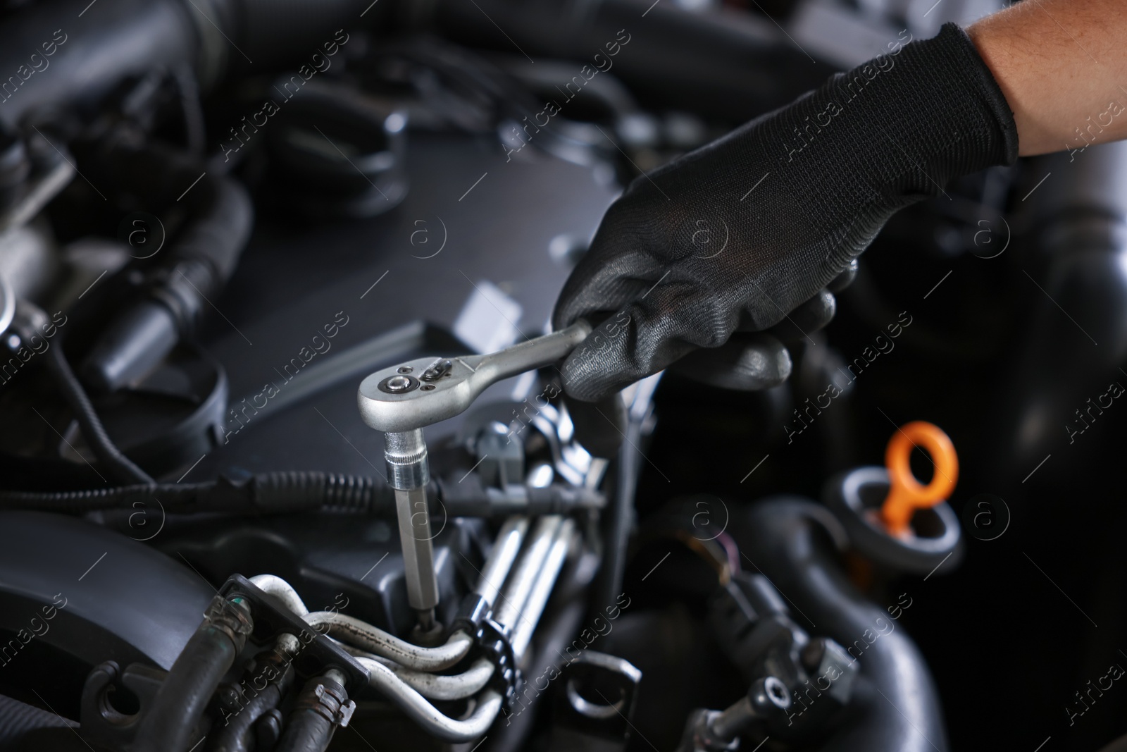 Auto parts. Professional mechanic with torque wrench fixing car indoors, closeup Photo of Auto parts. Professional mechanic with torque wrench fixing car indoors, closeup