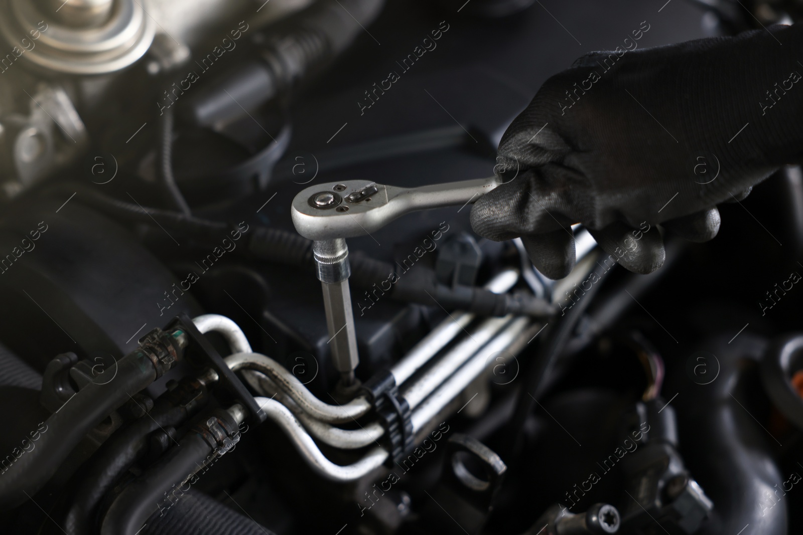 Auto parts. Professional mechanic with torque wrench fixing car indoors, closeup Photo of Auto parts. Professional mechanic with torque wrench fixing car indoors, closeup