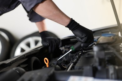 Photo of Auto parts. Professional mechanic with screwdriver fixing car indoors, closeup