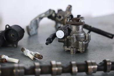 Photo of Different auto parts on grey table indoors, closeup