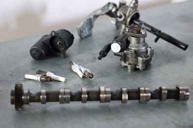 Photo of Different auto parts on grey table indoors, closeup