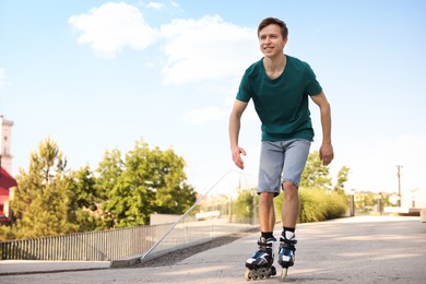 Photo of Happy man roller skating on city street. Space for text