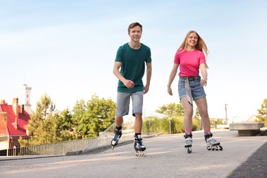 Photo of Happy couple roller skating together on street