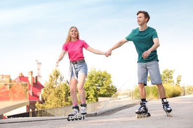 Photo of Happy couple roller skating together on street