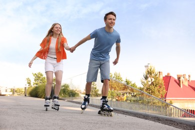 Photo of Happy couple roller skating together on street