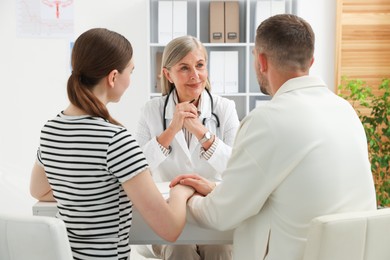 Photo of In vitro fertilization (IVF). Couple having consultation with doctor in reproductive clinic