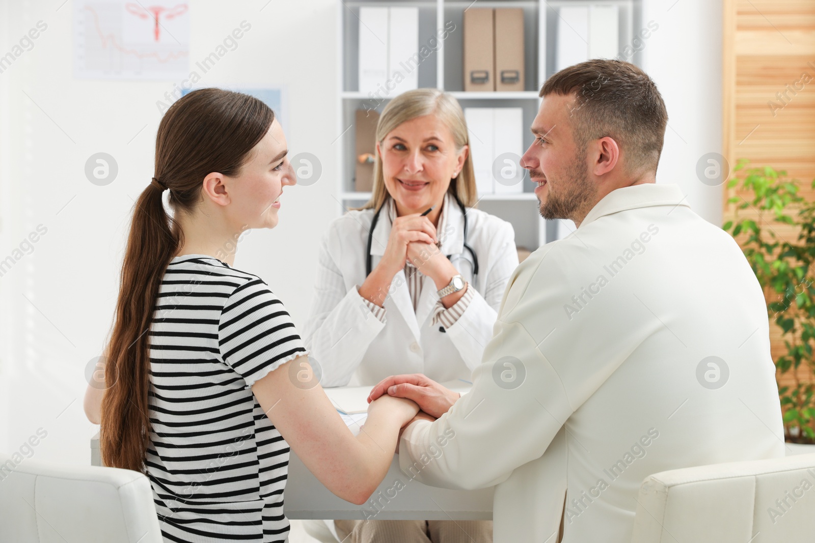 Photo of In vitro fertilization (IVF). Couple having consultation with doctor in reproductive clinic, selective focus