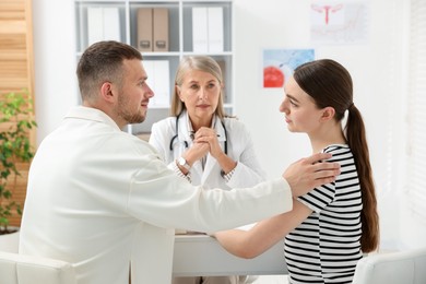 Photo of In vitro fertilization (IVF). Couple having consultation with doctor in reproductive clinic, selective focus