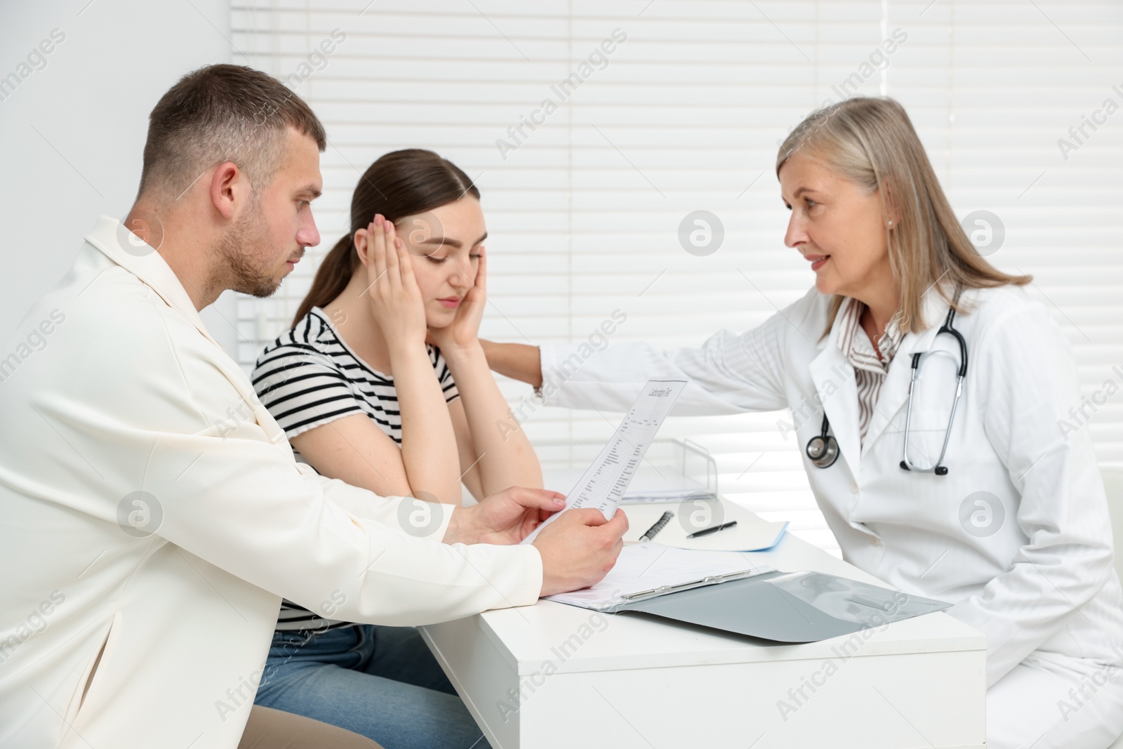 In vitro fertilization (IVF). Upset couple having consultation with doctor in reproductive clinic Photo of In vitro fertilization (IVF). Upset couple having consultation with doctor in reproductive clinic