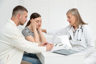 Photo of In vitro fertilization (IVF). Upset couple having consultation with doctor in reproductive clinic