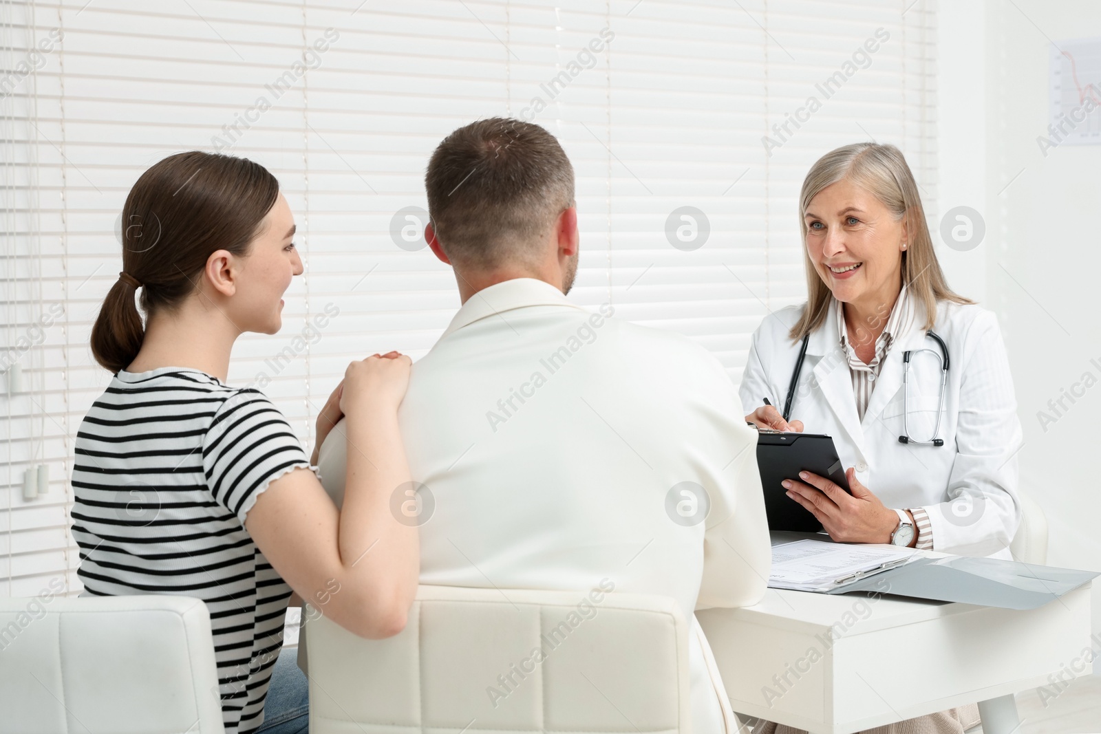 In vitro fertilization (IVF). Couple having consultation with doctor in reproductive clinic Photo of In vitro fertilization (IVF). Couple having consultation with doctor in reproductive clinic