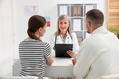 Photo of In vitro fertilization (IVF). Couple having consultation with doctor in reproductive clinic, selective focus