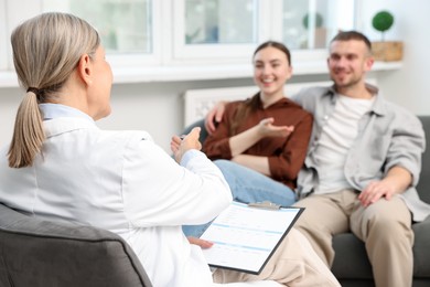 Photo of In vitro fertilization (IVF). Couple having consultation with doctor in reproductive clinic, selective focus