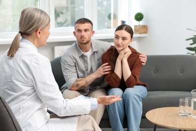 Photo of In vitro fertilization (IVF). Upset couple having consultation with doctor in reproductive clinic