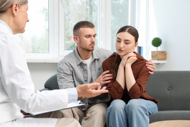 Photo of In vitro fertilization (IVF). Upset couple having consultation with doctor in reproductive clinic