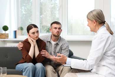 Photo of In vitro fertilization (IVF). Upset couple having consultation with doctor in reproductive clinic