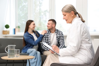 Photo of In vitro fertilization (IVF). Couple having consultation with doctor in reproductive clinic, selective focus