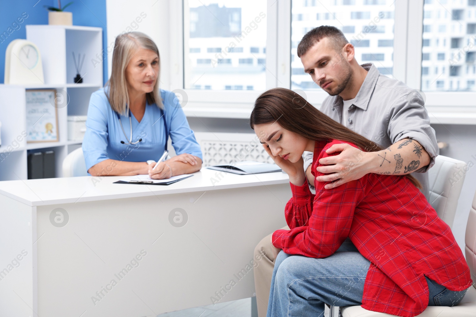 In vitro fertilization (IVF). Upset couple having consultation with doctor in reproductive clinic Photo of In vitro fertilization (IVF). Upset couple having consultation with doctor in reproductive clinic