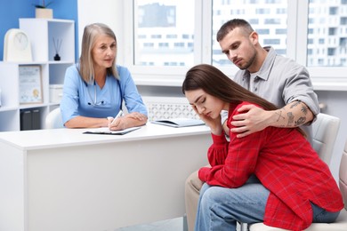 Photo of In vitro fertilization (IVF). Upset couple having consultation with doctor in reproductive clinic
