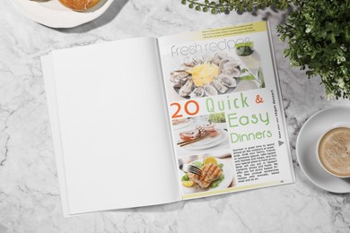 Photo of Open magazine, coffee and plant on white marble background, flat lay. Mockup for design