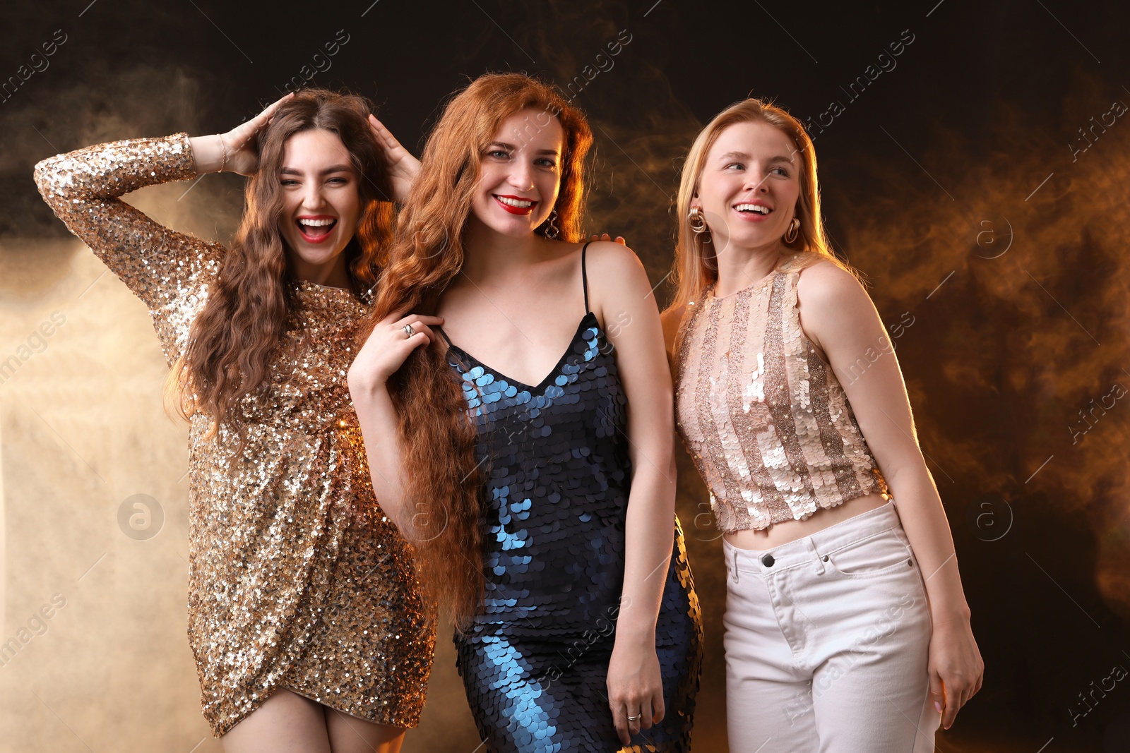 Photo of Beautiful women with different hair colors on dark background with smoke