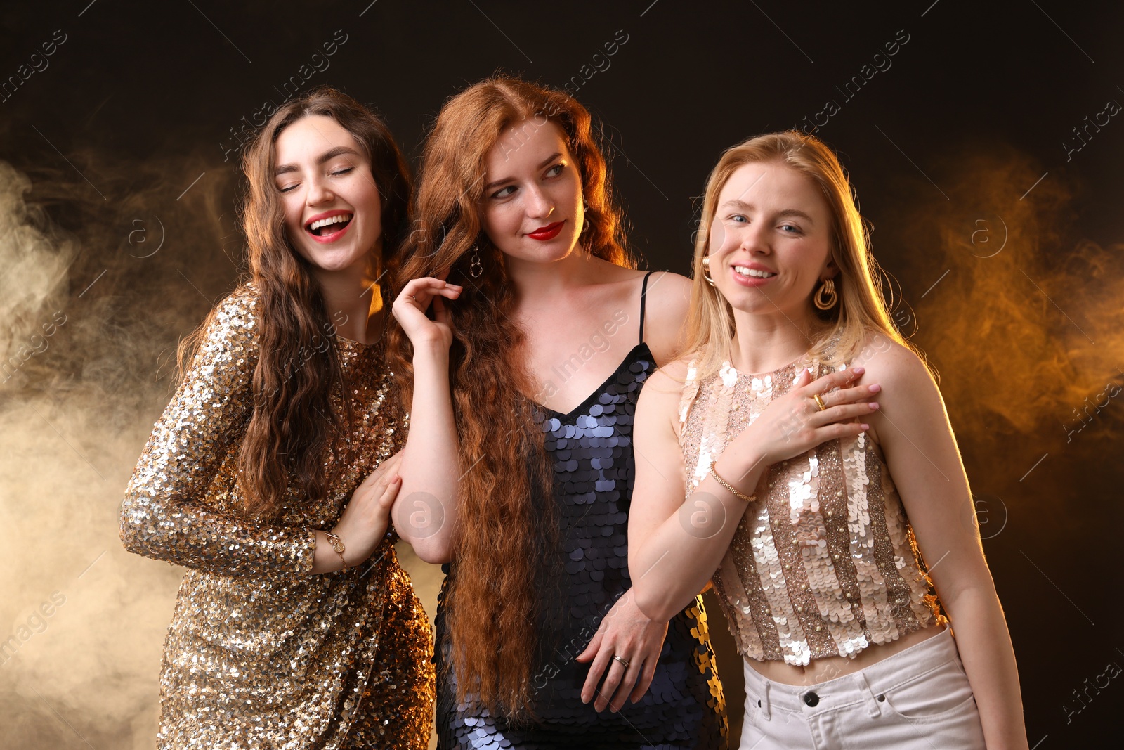 Beautiful women with different hair colors on dark background with smoke Photo of Beautiful women with different hair colors on dark background with smoke