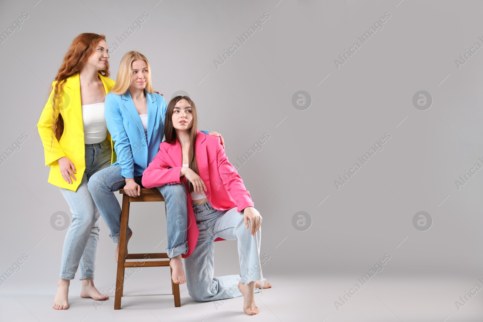 Photo of Beautiful women with different hair colors on light grey background, space for text