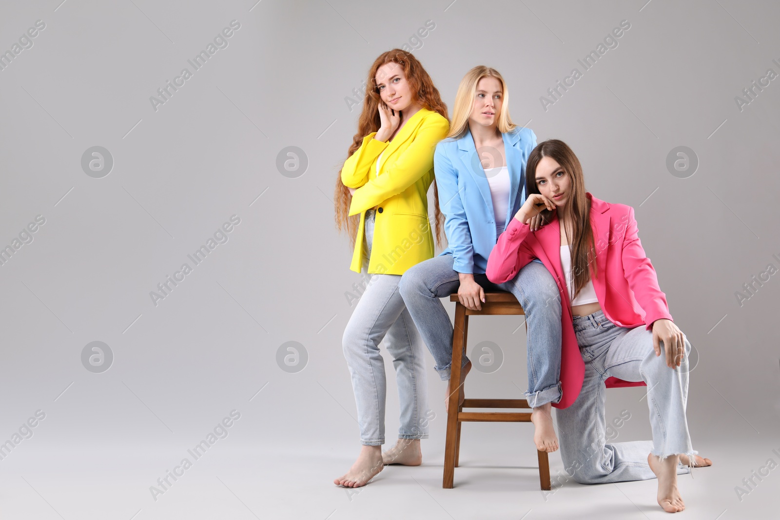 Photo of Beautiful women with different hair colors on light grey background, space for text